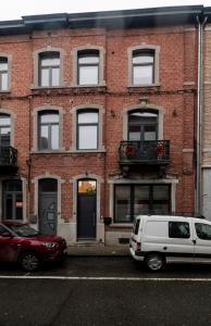 two cars parked in front of a brick building at Les Gîtes Du Palais in Dinant