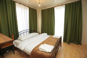库塔伊西CHOGO Hotel Kutaisi的卧室里有一张带绿色窗帘的大床