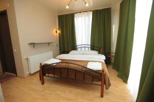 a bedroom with a bed with green curtains at CHOGO in Kutaisi