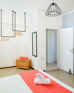 a bedroom with a bed with a red rug and a chandelier at Crops Suites in Heraklio
