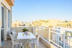 a white table and chairs on a balcony with a view at Crops Suites in Heraklio Town