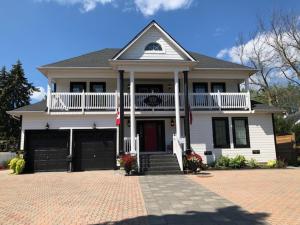 Cette maison blanche dispose d'un balcon et d'une allée. dans l'établissement Casa Blanca Boutique Bed & Breakfast, à Niagara on the Lake