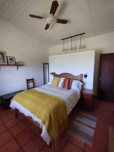 a bedroom with a bed and a ceiling fan at Casa de campo CLARA LUNA Sierra y Mar in Punta Ballena