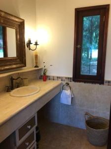 baño con lavabo, espejo y ventana en Casa de campo CLARA LUNA Sierra y Mar, en Punta Ballena