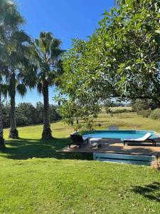 una piscina en un campo con palmeras en Casa de campo CLARA LUNA Sierra y Mar, en Punta Ballena