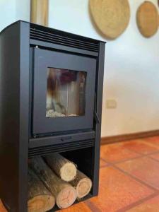 a black tv with logs inside of a fireplace at Casa de campo CLARA LUNA Sierra y Mar in Punta Ballena