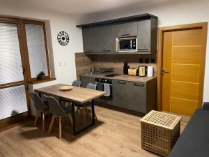 een keuken met een tafel en stoelen in een kamer bij New Apartment Matilda - Tatranská Lomnica in Tatranská Lomnica