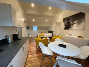 a kitchen and living room with a white table and chairs at Les Gîtes Du Palais in Dinant
