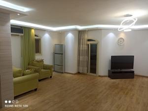a living room with a couch and a tv at شقة مفروش ٣ غرف و٢ حمام سرايات المعادى in Cairo