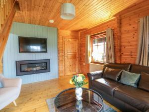 a living room with a couch and a table at Moyle Lodge in Dalbeattie