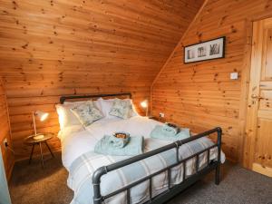 a bedroom with a bed in a log cabin at Moyle Lodge in Dalbeattie