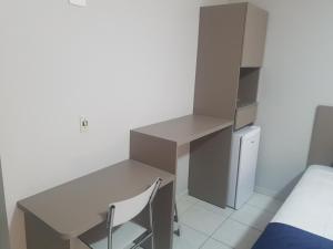 Cette chambre comprend un bureau et une chaise. dans l'établissement Flat na Riviera de São Lourenço, à Riviera de São Lourenço
