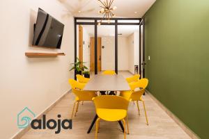 a dining room with a table and yellow chairs at Torre Sofia magnific apartments & estudios with great amenities in Cancún