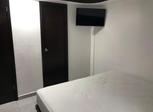 a bedroom with a bed and a flat screen tv at Hotel magallanes con cocineta 100 Metros de playa in Acapulco
