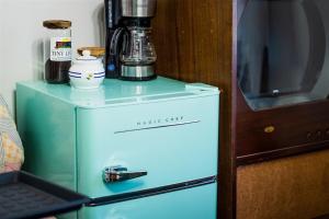 Elle comprend un petit réfrigérateur bleu avec une cafetière. dans l'établissement Restored 1930’s Tiny Home 3 min to Cape Charles, à Cape Charles