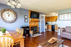 a living room with a table and a clock on the wall at WOW Views!!-Mountain Escape-Outdoor Pool-Close to Downtown-WiFi-Cable-Private Balcony in Gatlinburg +48 photos