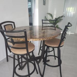 uma mesa de jantar com quatro cadeiras, uma mesa e uma planta em Paradise Escape em Barceloneta