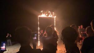 a group of people watching a fire show in the dark at Kohmak HomeHug&Beachclub in Ko Mak