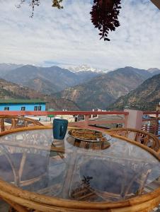 una mesa de cristal con vistas a las montañas en Kedar View Homestay en Ukhimath
