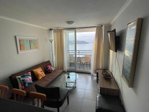 a living room with a couch and a table at Apartamento junto a la playa - Vistas Increíbles in Coquimbo