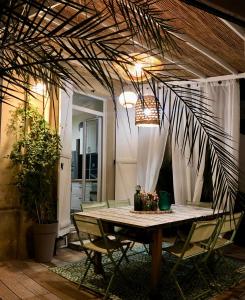 a dining room table with chairs and a potted plant at Le Nid Cosy in Bordeaux