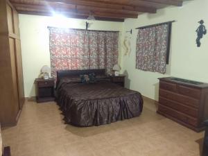 a bedroom with a bed and a dresser and curtains at CASA SILVIA NECOCHEA in Necochea