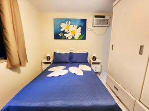Un dormitorio con una cama azul con flores. en Studio no Coração do Leblon JL311, en Río de Janeiro