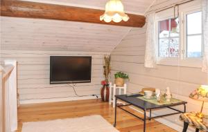 a living room with a flat screen tv on a wall at Lovely Home In Gunnarskog With House A Panoramic View in Gunnarskog