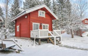 a red tiny house in the snow at Lovely Home In Gunnarskog With House A Panoramic View in Gunnarskog