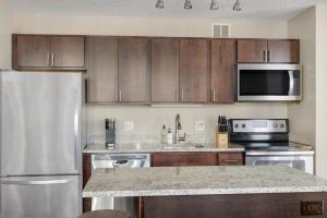 a kitchen with stainless steel appliances and wooden cabinets at Kasa Magnificent Mile Chicago in Chicago