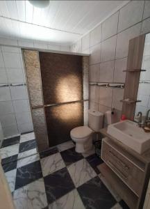 un baño con inodoro y lavabo en Casa de Veraneio Laranjal, en Pelotas 4 fotos más