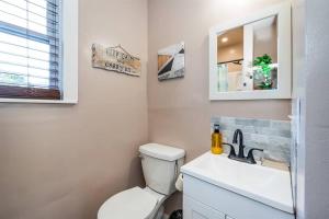 a bathroom with a toilet and a sink and a mirror at Pet Friendly Tiny Livin 3min from Cape Charles in Cape Charles
