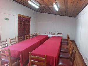 Hotel Real del Campo في كويتزالتنانغو: قاعة اجتماعات فيها طاولات حمراء وكراسي