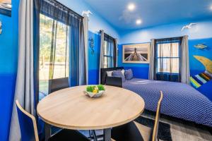 Dormitorio azul con mesa y cama en Whimsical Tiny House, Cape Charles Virginia, en Cape Charles