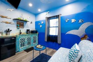 a room with blue walls and a kitchen with a counter at Whimsical Tiny House, Cape Charles Virginia in Cape Charles