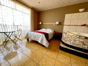 Un dormitorio con una cama y una mesa. en Hotel los angeles, en Huaral