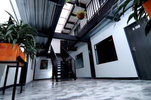 a hallway with stairs and potted plants in a building at Hotel Casa Malibú in Medellín