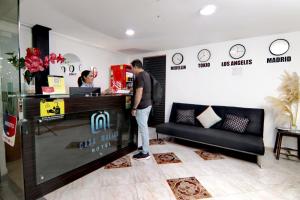 a man and a woman standing at a counter in a store at Hotel Casa Malibú in Medellín