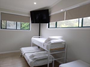 a room with three bunk beds and two windows at T's Resort & Motel in Port Macquarie