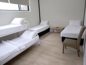 um quarto com 3 beliches e uma cadeira em T's Resort & Motel em Port Macquarie