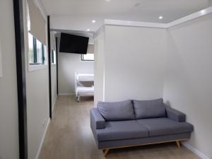 a living room with a couch and a television at T's Resort & Motel in Port Macquarie