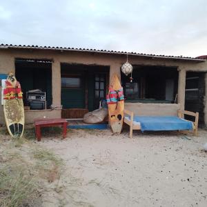 una casa con una cama y tablas de surf delante de ella en Calavera Beach Hostel, en Cabo Polonio
