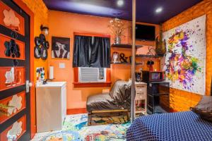 een slaapkamer met oranje muren, een bed en een bureau bij Red House Tiny Home in Cape Charles