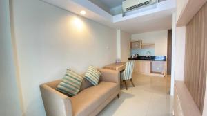 a small living room with a couch and a kitchen at Swiss-Belcourt Bogor in Bogor