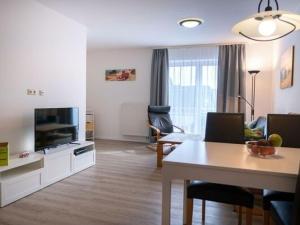 a living room with a television and a dining table at Resort Orther Reede, Fehmarn-Orth in Orth