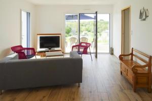 a living room with a couch and chairs and a television at Holiday Home Morgat near Sandy Beach in Morgat