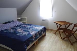 a bedroom with a bed and a table and a chair at Holiday Home Morgat near Sandy Beach in Morgat
