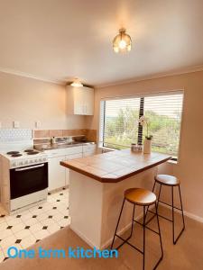 a kitchen with a counter and two bar stools at Habour View - Tauranga Central in Tauranga