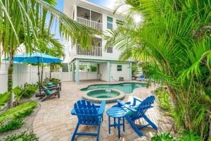 a patio with blue chairs and a swimming pool at Found Your Sol Mate Gorgeous Home w Pool Spa Steps to Bean Point Dogs OK in Anna Maria