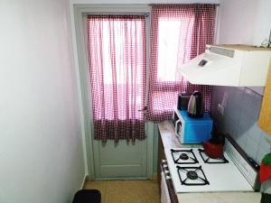 una piccola cucina con piano cottura e finestra di Monte Friendly a Monte Hermoso